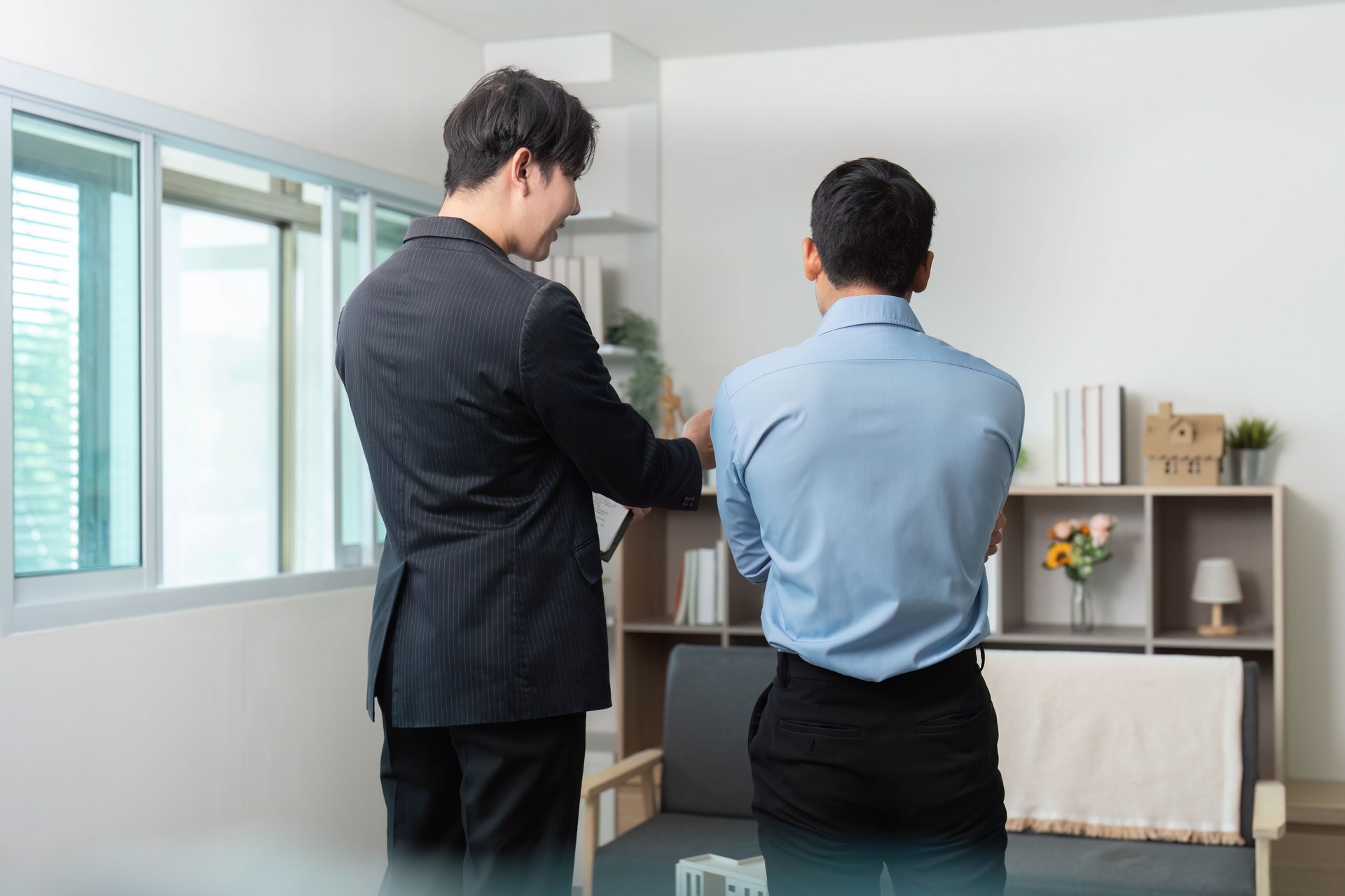 Réunion d’affaires. Deux professionnels discutent des détails du projet dans un bureau moderne.